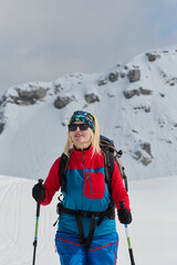 A professional woman skier rejoices after successfully climbing the snowy peaks of the Alps