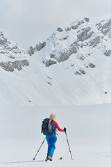A professional woman skier rejoices after successfully climbing the snowy peaks of the Alps