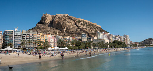 Postiguet beach in the city center of Alicante with the ruins of the historic Santa Barbara castle in the background, Alicante, Spain