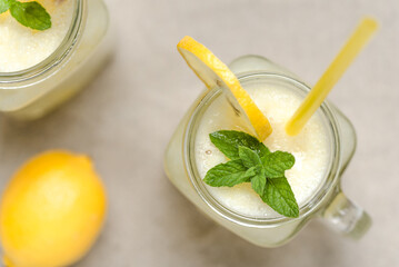 Two lemonade in glass jars on sand beach. Fresh summer drinks, close up, top view. - 783081463