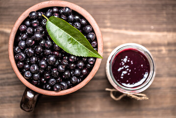 Aronia jam and fresh berry on wooden table. - 783082246