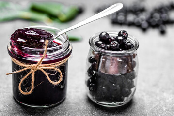 Aronia jam and fresh berry on stone table. - 783082626