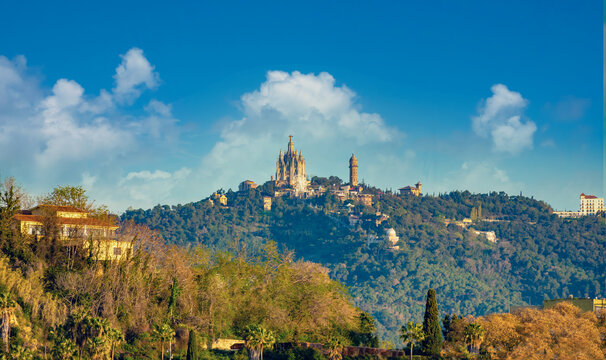 The famous Tibidabo hill overlooking Barcelona, Catalonia, Spain. On the summit the iconic Sagrat Cor church the Tibidabo Amusement Park and the water tower.