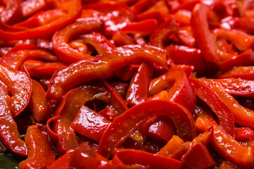 Grilled pepper sliced in stripes. Red pepper background. - 783084867
