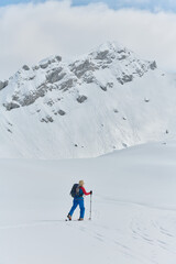 Fototapeta na wymiar A professional woman skier rejoices after successfully climbing the snowy peaks of the Alps