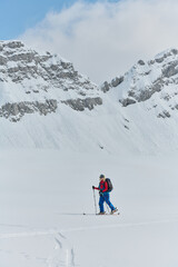 Fototapeta na wymiar A professional woman skier rejoices after successfully climbing the snowy peaks of the Alps