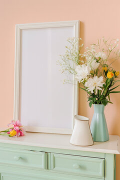 Mock up photo frame with plants in vase on a green dresser and peach wall, minimalism. Vertical orientation. Elegant personal accessories.