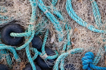 Fishing nets on the pier in the evening light. Fishing nets and ropes on the beach. Fishing nets...