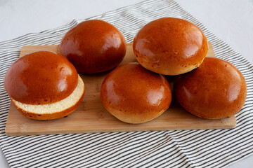 Homemade Brioche Hamburger Buns on a wooden board, side view. - 783094430