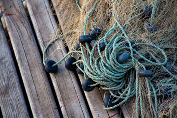 Fishing nets on the pier in the evening light. Fishing nets and ropes on the beach. Fishing nets...