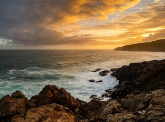 Orange sunrise over the ocean. View from a cliff on a rocky shore.