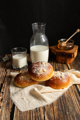 Fresh rolls with milk. on a dark wooden background. morning