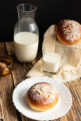 Fresh rolls with milk. on a dark wooden background. morning