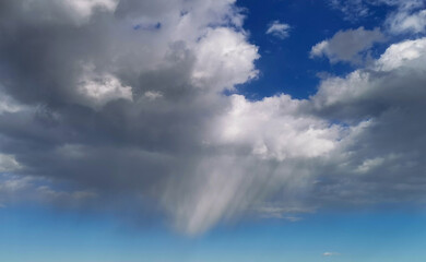 La pioggia cade dalle nuvole nel cielo sopra al mare