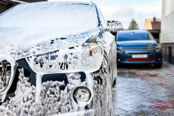 Manual car wash with high pressure washing outside.