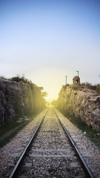 railway track in the mountains with light coming from the other side