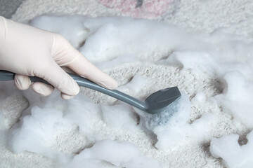 Blue brush on the floor with hand in rubber glove. Cleaning.