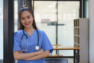 Asian female doctor with stethoscope and standing with arms crossed in hospital, Health care and...
