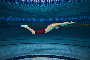 Butterfly swim style. Athletic young man, swimmer in motion training, preparing for competition,...