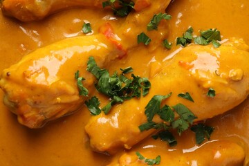 Tasty chicken curry with parsley as background, top view