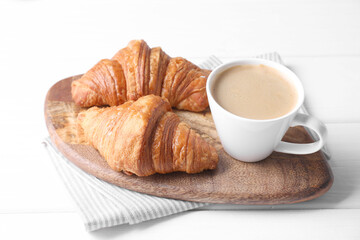 Tasty breakfast. Cup of coffee and croissants on white wooden table