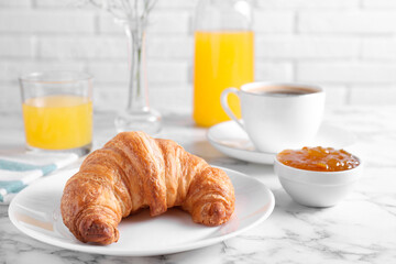 Tasty breakfast. Fresh croissant and jam on white marble table