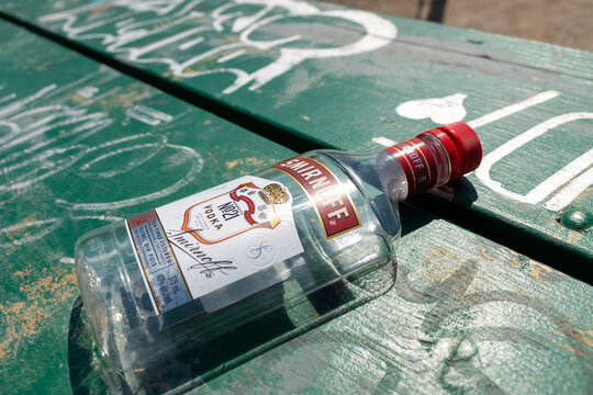 empty plastic bottle of Smirnoff on a park table