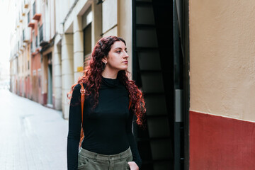 Traveler with piercings observes the city while walking through its streets