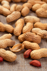 Delicious peanuts on burlap close-up. Peanut background - 783111258