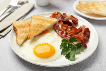 Delicious breakfast with sunny side up egg served on light table, closeup