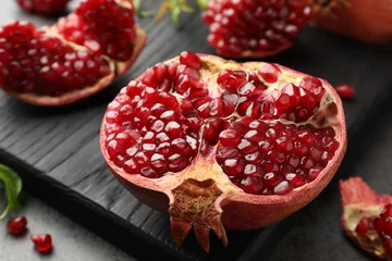 Fotobehang Cut fresh pomegranate on grey table, closeup © New Africa