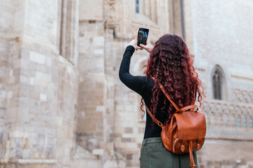 Tourist taking photos of a historic building in the old town of a european city