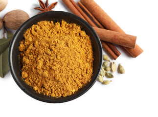 Dry curry powder in bowl and other spices isolated on white, top view