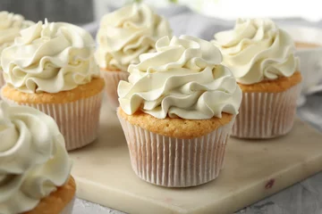 Rolgordijnen Tasty cupcakes with vanilla cream on grey table, closeup © New Africa