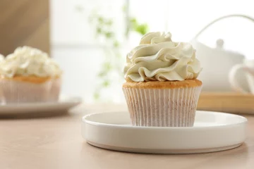 Tuinposter Tasty cupcake with vanilla cream on light wooden table, closeup. Space for text © New Africa