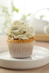 Rolgordijnen Tasty cupcake with vanilla cream on light wooden table, closeup © New Africa