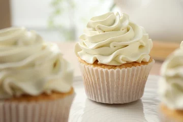 Rolgordijnen Tasty cupcakes with vanilla cream on table, closeup © New Africa