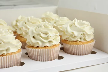 Rolgordijnen Tasty cupcakes with vanilla cream in box, closeup © New Africa