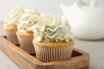 Zelfklevend Fotobehang Tasty cupcakes with vanilla cream on light grey table, closeup © New Africa