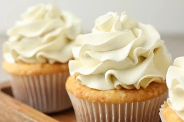 Rolgordijnen Tasty cupcakes with vanilla cream on table, closeup © New Africa