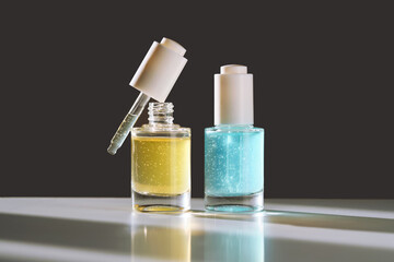 Yellow and blue serums with pipettes against the background of the sun.