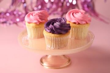 Delicious cupcakes with bright cream on pink background, closeup