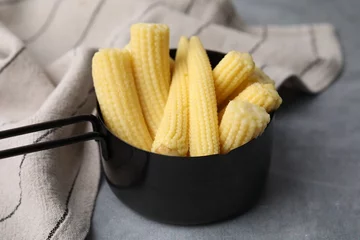 Foto op Canvas Tasty fresh yellow baby corns in dish on grey table, closeup © New Africa