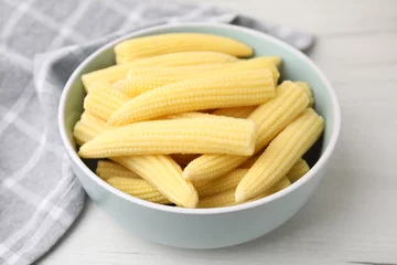 Outdoor kussens Tasty fresh yellow baby corns in bowl on white wooden table © New Africa