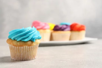 Foto op Canvas Delicious cupcakes with bright cream on gray table, selective focus © New Africa