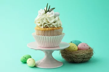 Gordijnen Tasty Easter cupcake with vanilla cream and festive decor on turquoise background © New Africa