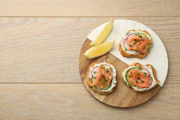  Tasty canapes with salmon served on wooden table, top view. Space for text © New Africa