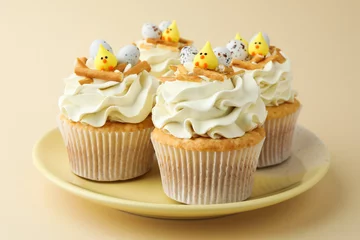 Foto op Canvas Tasty Easter cupcakes with vanilla cream on beige background © New Africa