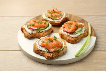 Fotobehang Tasty canapes with salmon served on wooden table © New Africa
