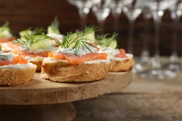 Fotobehang Tasty canapes with salmon, cucumber, cream cheese and dill on wooden table, closeup. Space for text © New Africa